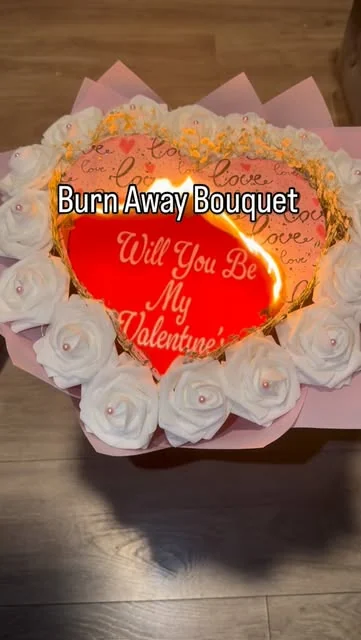 Burn Away bouquet: a heart burning away to reveal Will You Be My Valentine, surrounded by white roses